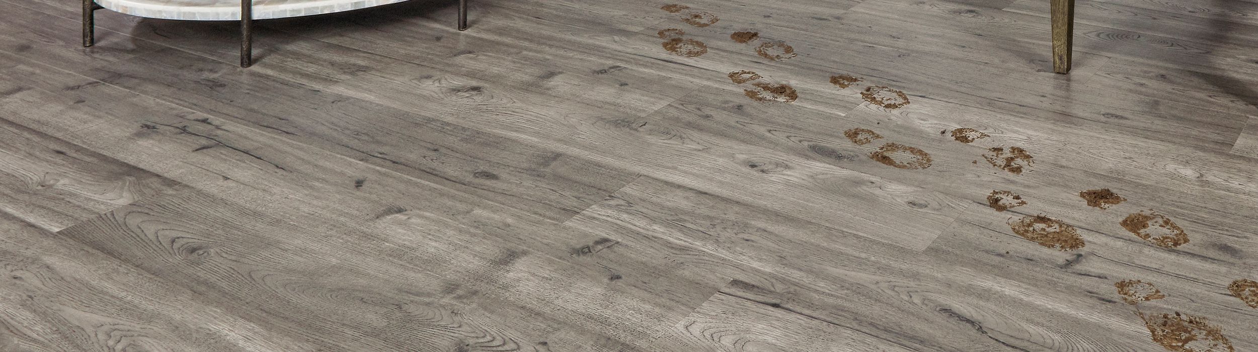 light grey pergo laminate floors with muddy footprints
